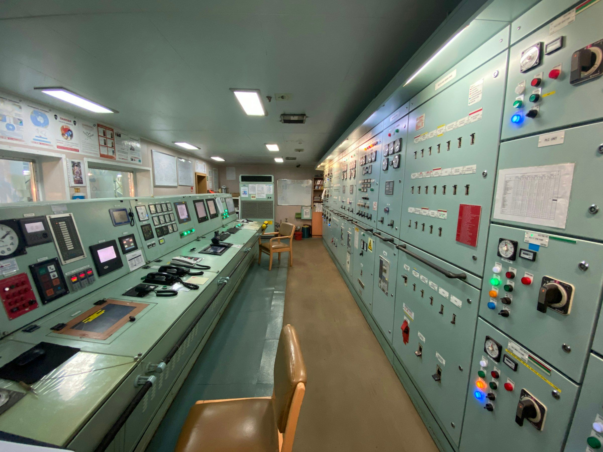 Industrial control room with multiple operator workstations and process monitoring screens